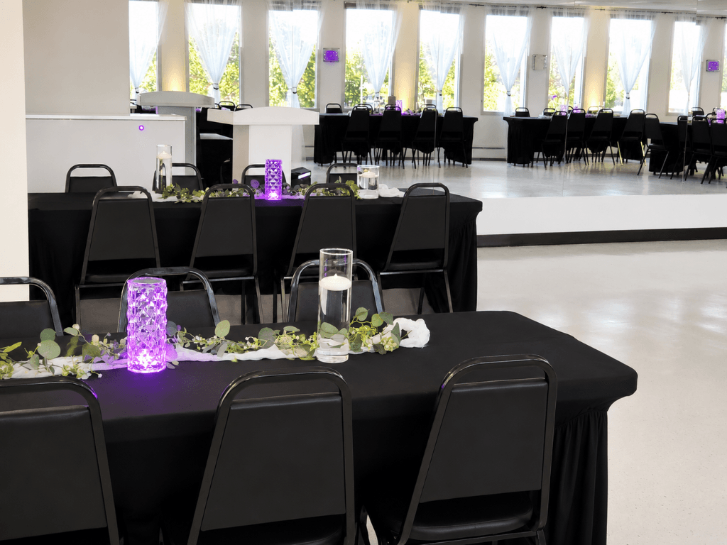 Black tables with purple centerpieces and mirrors