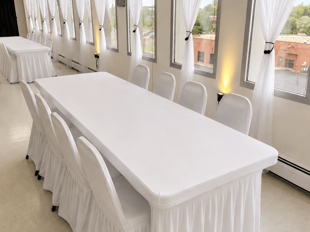 Signature package White banquet table with chair covers by windows