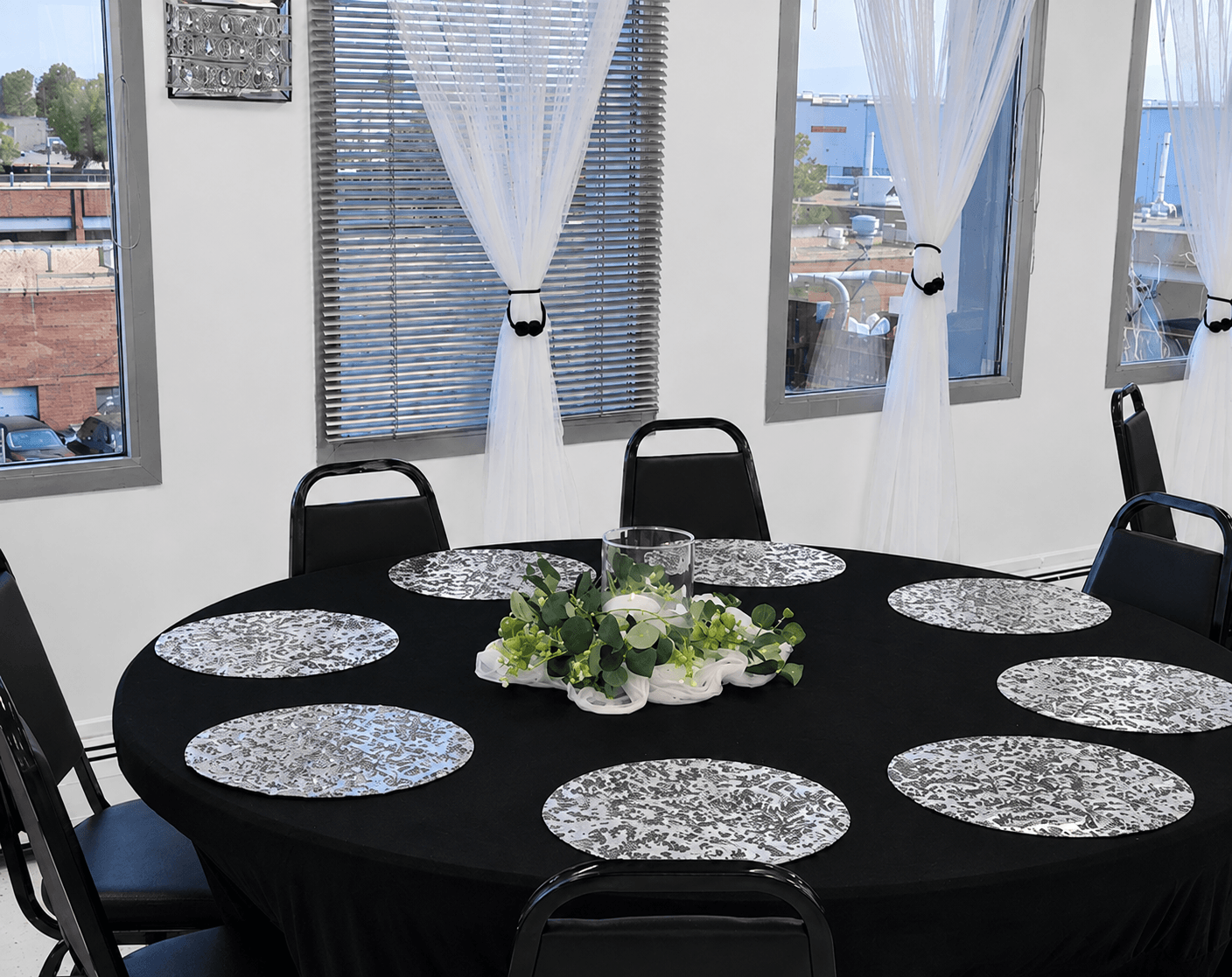 Celebrations Party Event Rental Package set up at TD Event Space in Denver with black tablecloths and silver fabric place mats & black banquet chairs.
