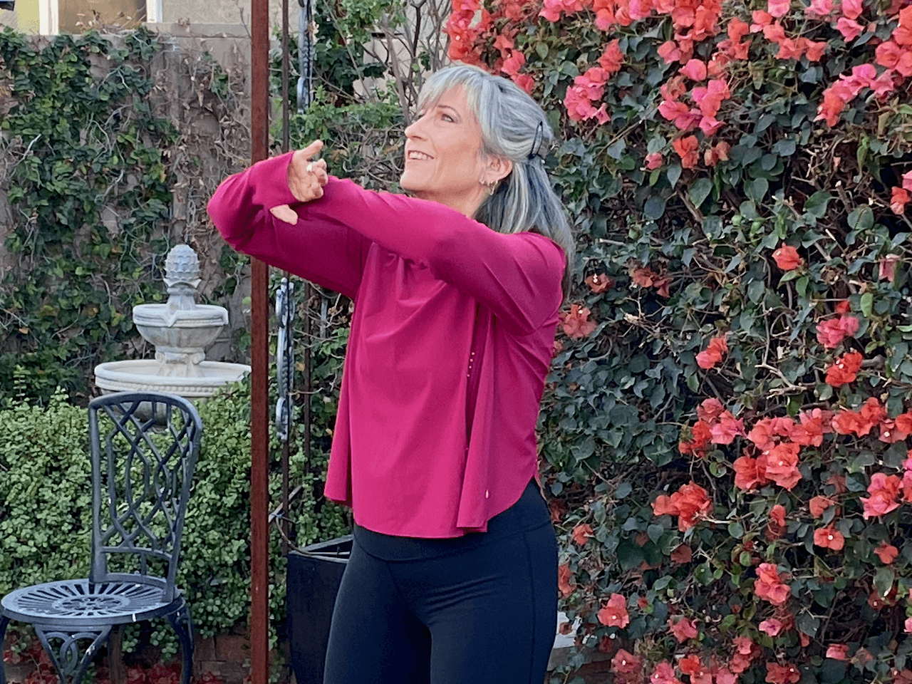Sharlyn practicing mindful movement outdoors in a garden.