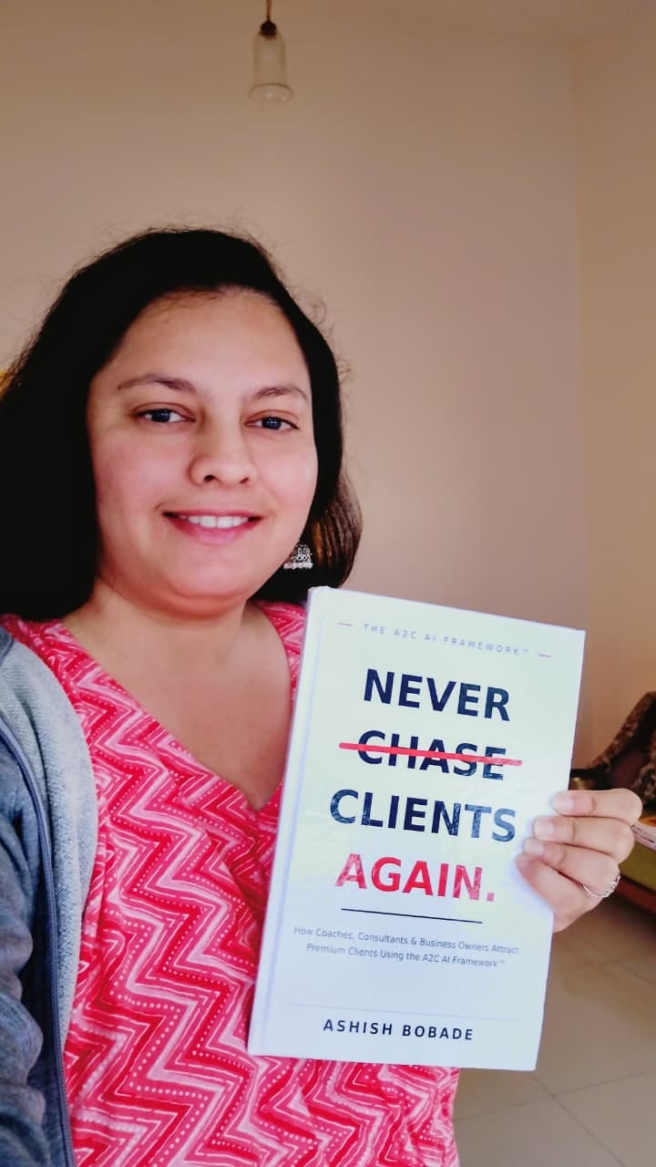 Rashmi Raikar with a copy of Never Chase Clients Again