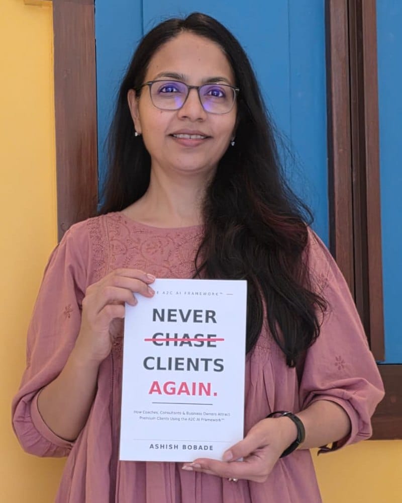 Divya Jain with a copy of Never Chase Clients Again