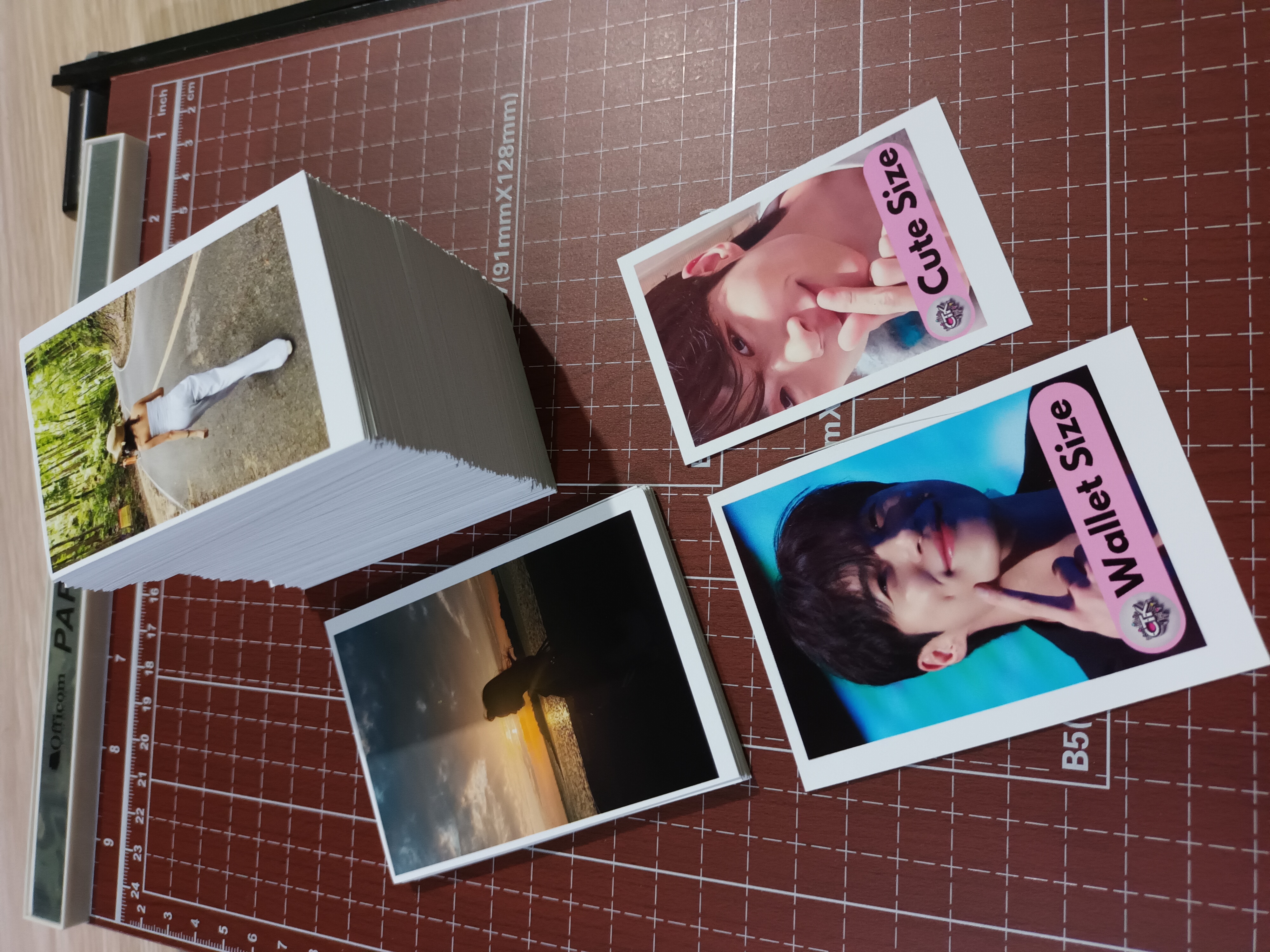 A tall stack of printed photos in cute and wallet sizes