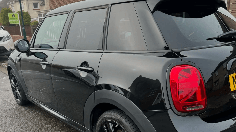 Heavily soiled black Mini Cooper before exterior valet service
