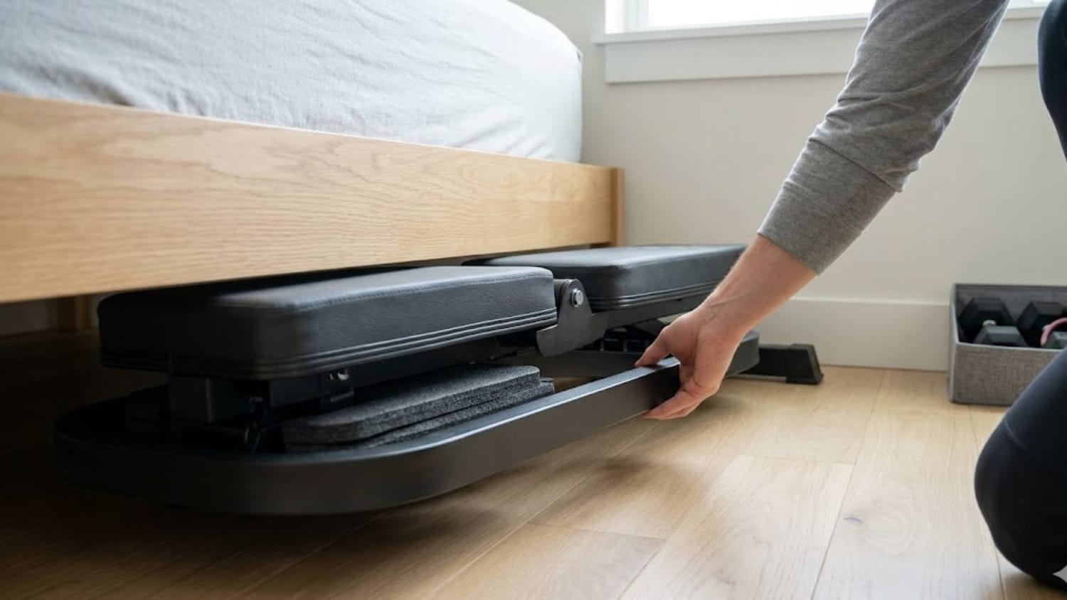 foldable weight bench folded flat and sliding under an apartment bed for storage