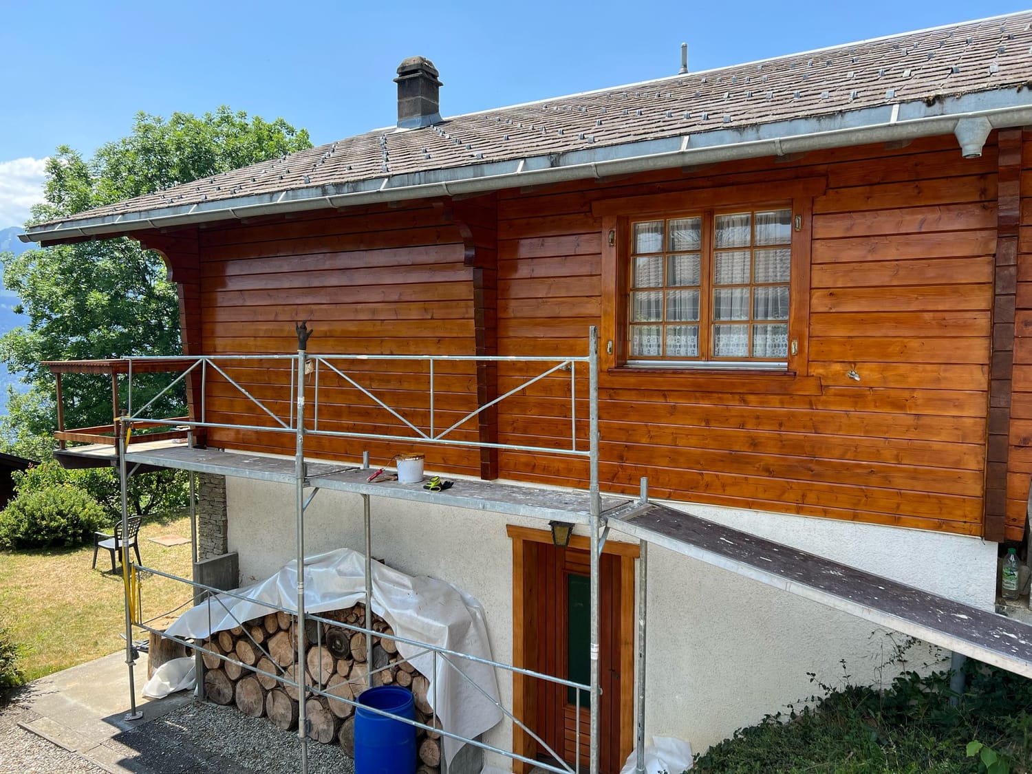 Façade en bois du chalet restaurée, vue sur la vallée