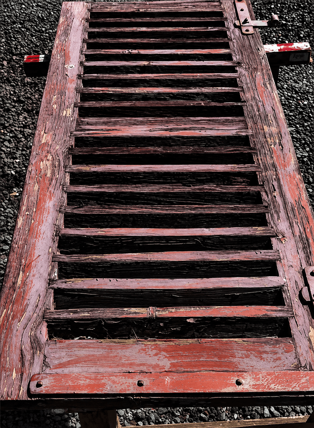 Volet en bois avec peinture rouge écaillée avant restauration