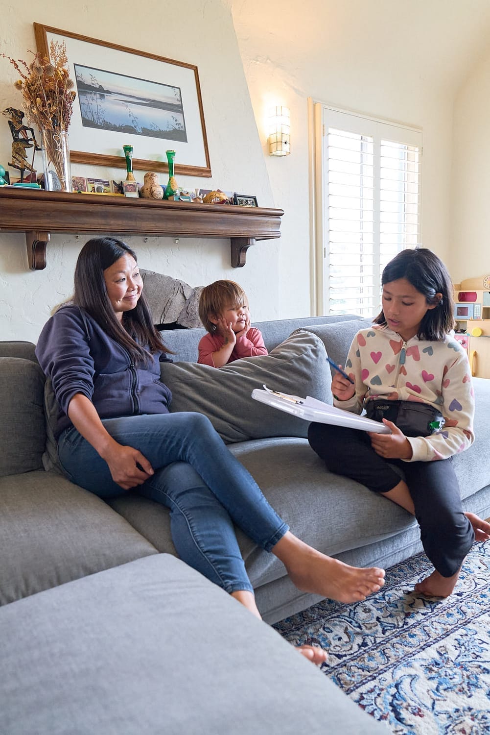 Carys discussing life skills with a mom and baby, taking notes as part of a life skills program for students.