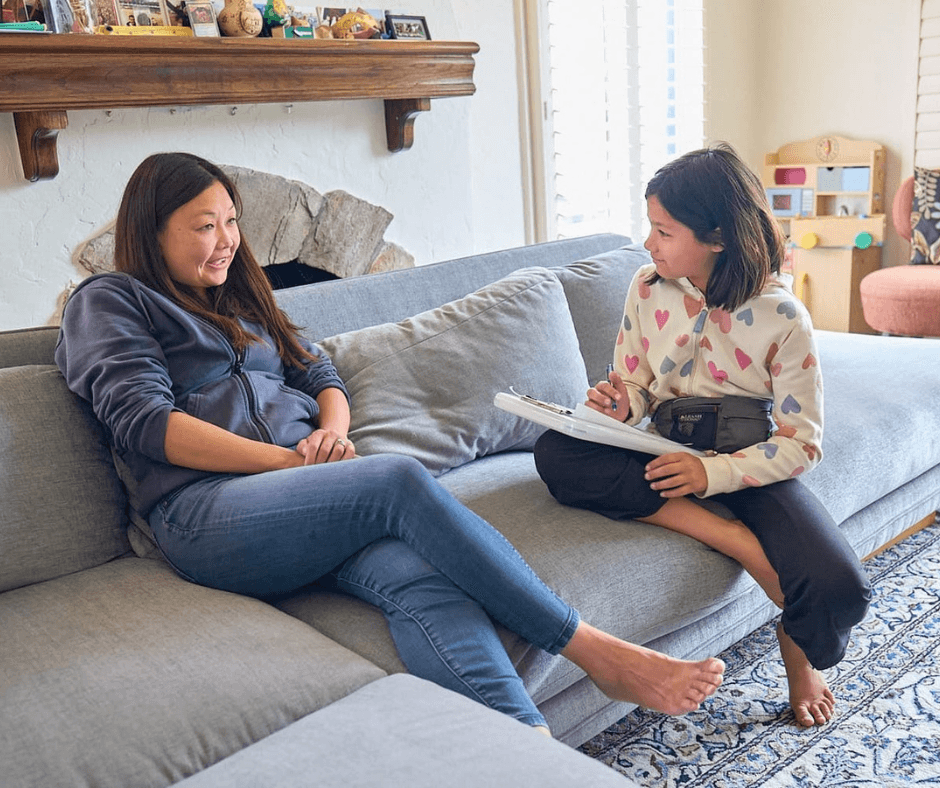 Carys engaged in conversation with a woman, taking notes for a life skills course focused on childhood independence.