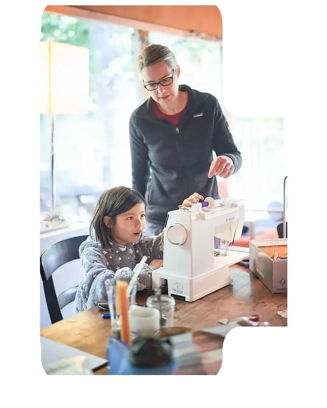 Carys sewing with the help of an instructor, learning practical life skills and executive function activities for kids.
