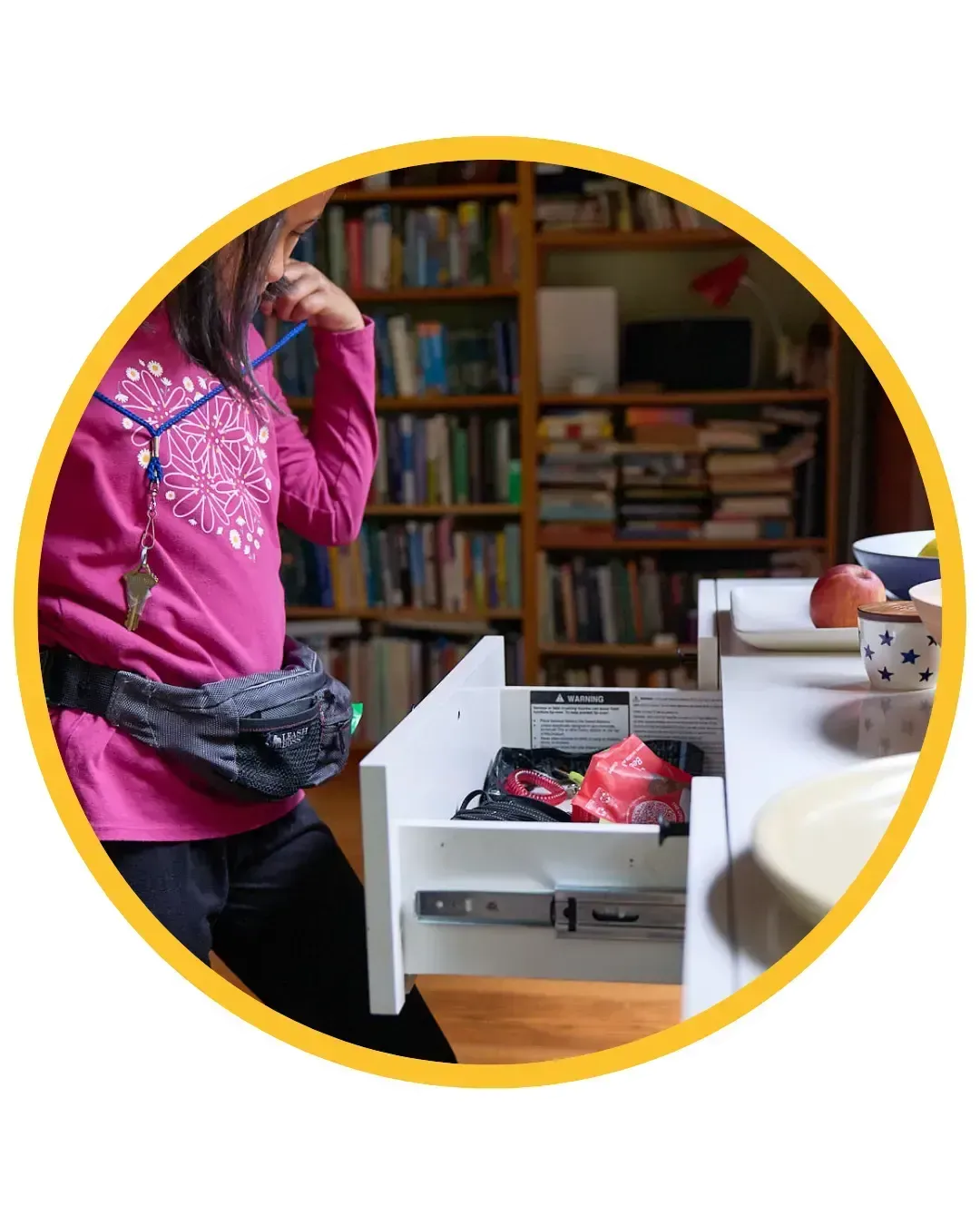 Carys placing a key around her neck — a milestone in life skills training and childhood independence.