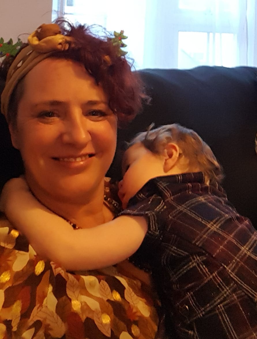 Jenny holding a sleeping child during an evening of holiday childcare in the Dordogne