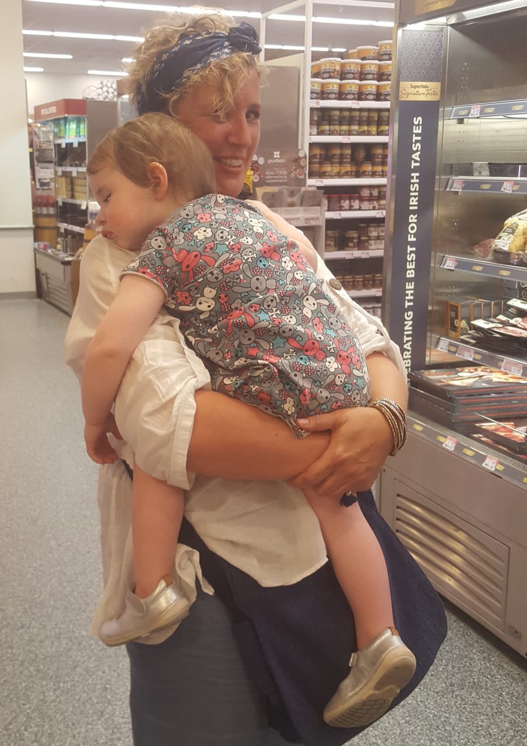Jenny carrying a sleeping child after a busy day together.