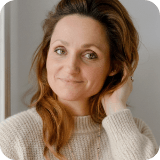 warm natural portrait of a woman coach with curly auburn hair, soft light, calm expression