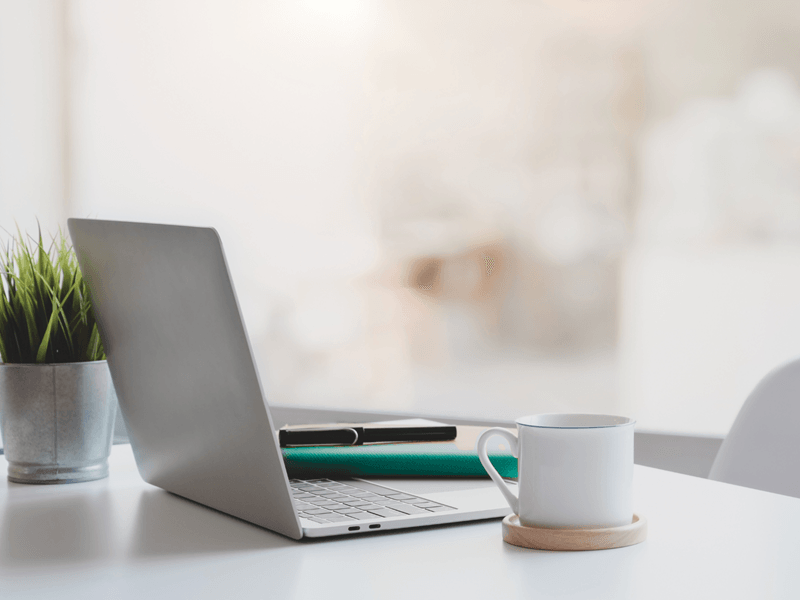 Minimalistyczna scena biurka z laptopem i notesem, symbol pracy nad sobą i dojrzałości.