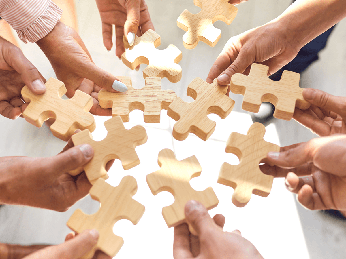 Osoby trzymają puzzle, symbol zespołu w zmianie