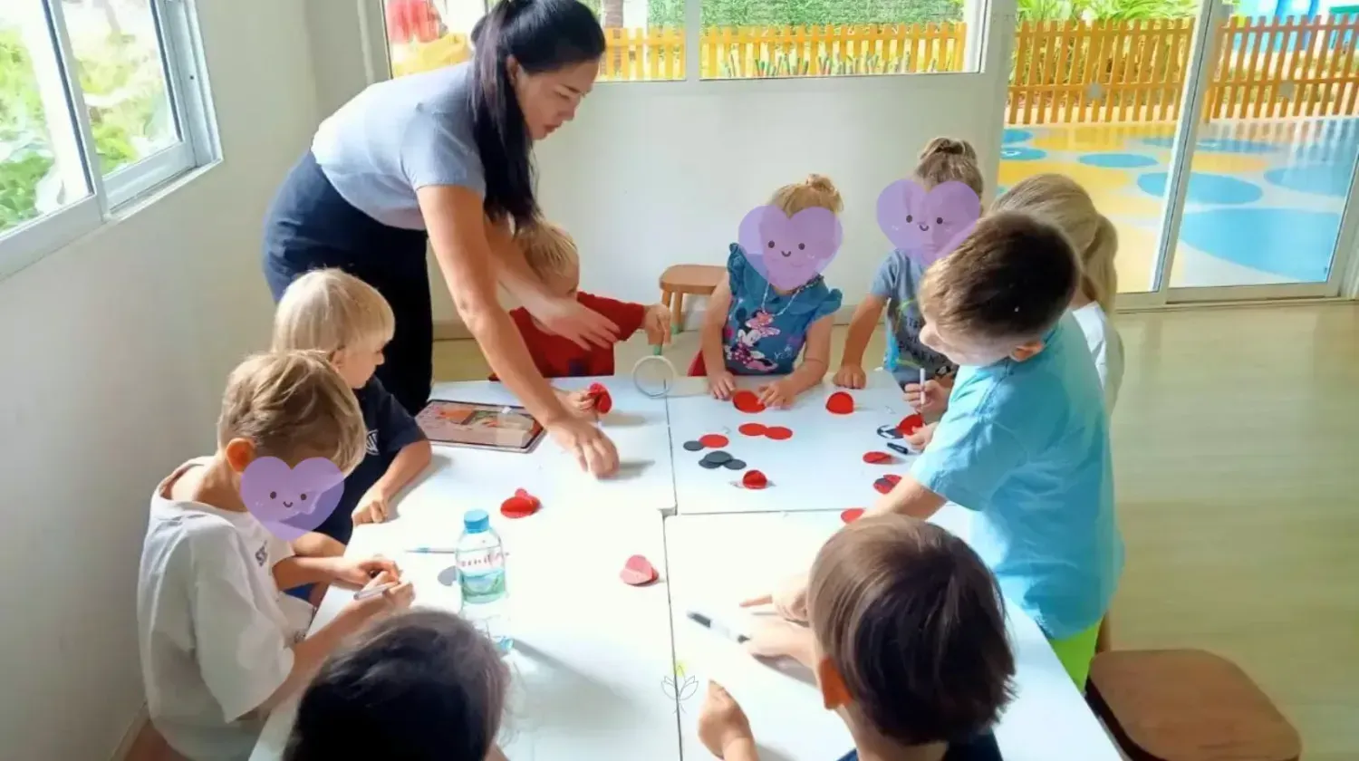 Children in a classroom in Thailand with a teacher guiding them, showing expat-friendly education.