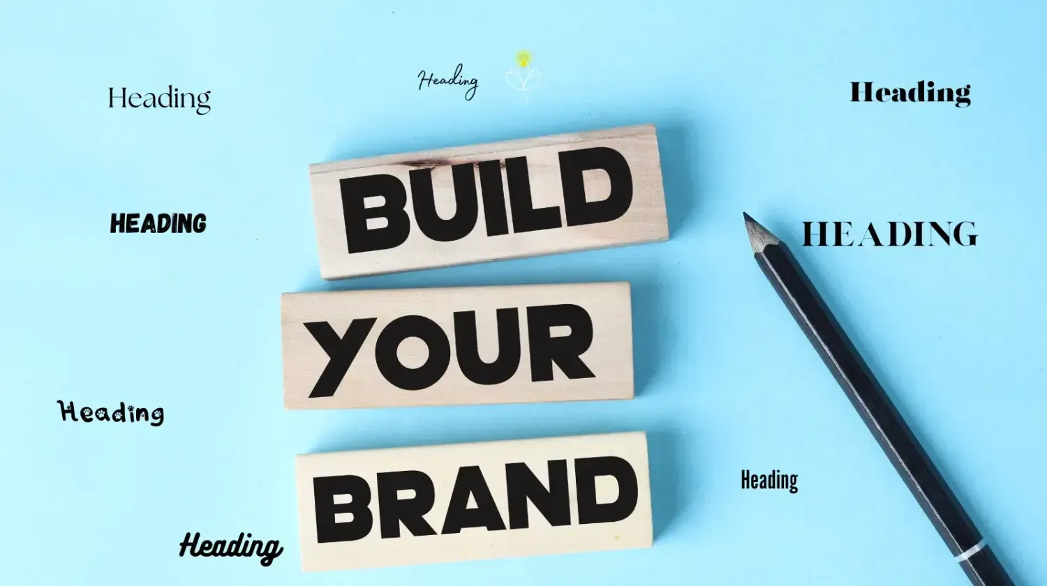 Wooden blocks spelling “Build Your Brand” next to a pencil, symbolizing the start of creating texts and visuals for your website.