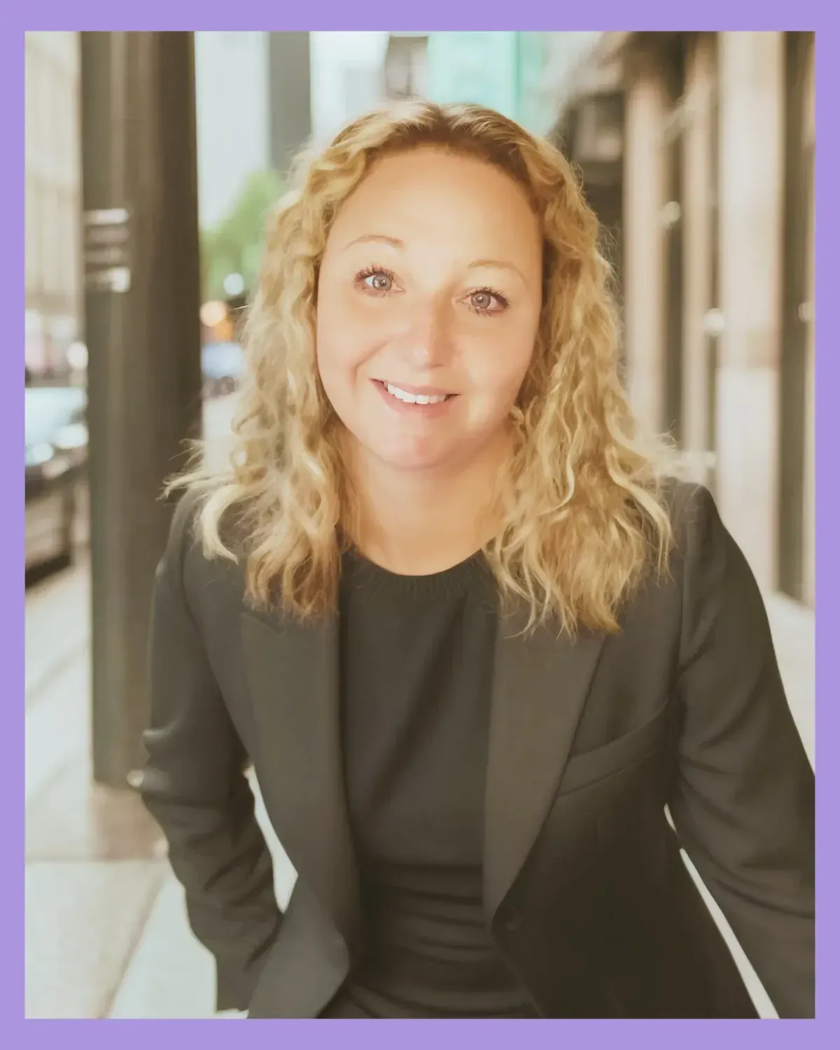 Smiling female business coach in a blazer, ready to help clients gain clarity and confidence during a 1:1 online coaching call.