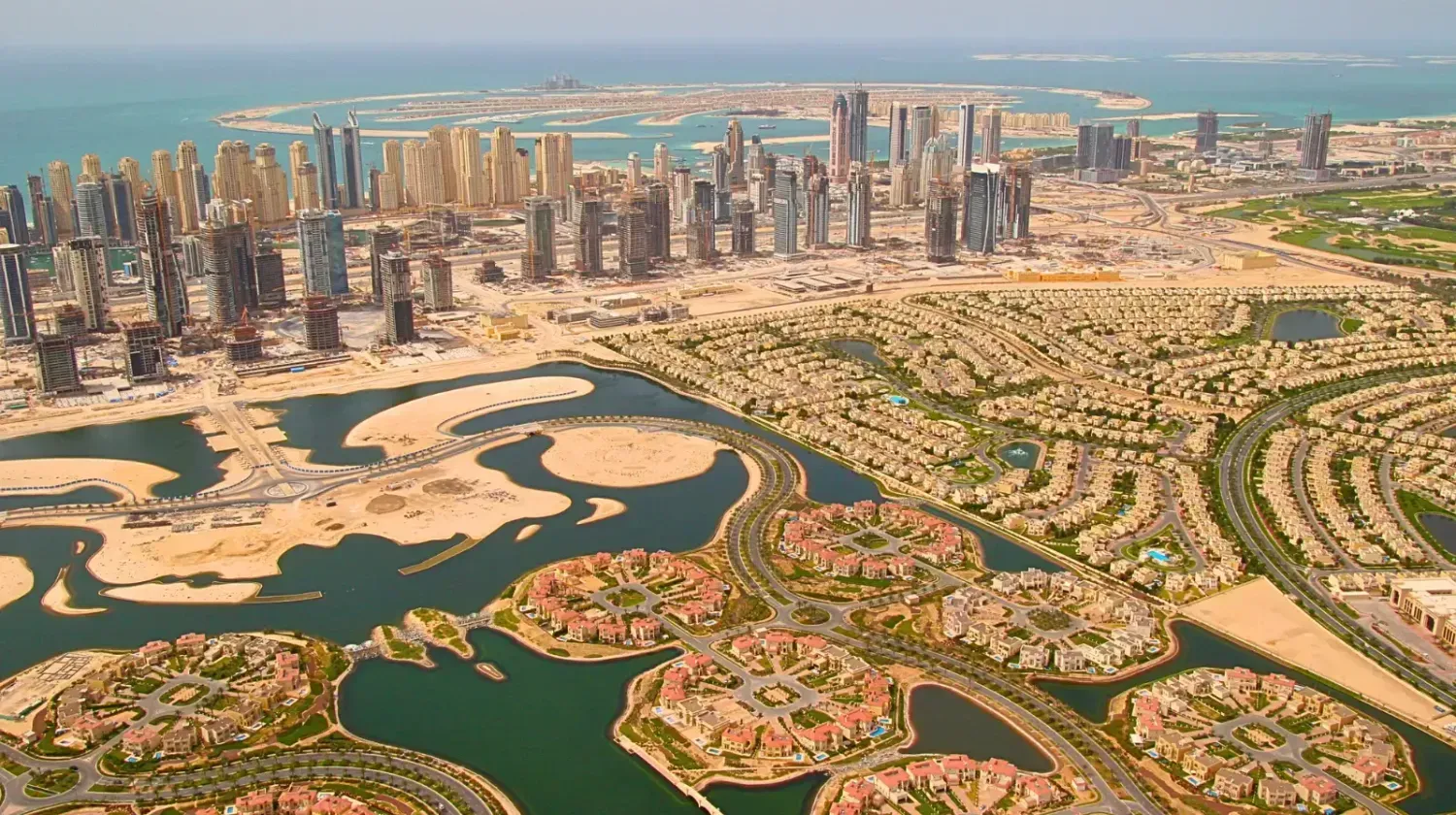 Aerial view of Dubai’s coastline and artificial islands — how urban design and city layout impact real estate investment opportunities.