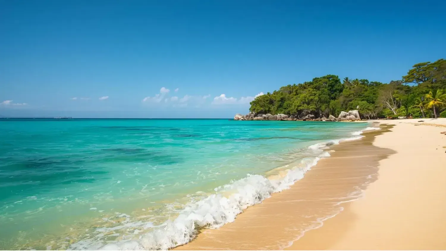 Peaceful tropical beach with turquoise water, golden sand, and lush green island under a bright blue sky in Phuket, Thailand.