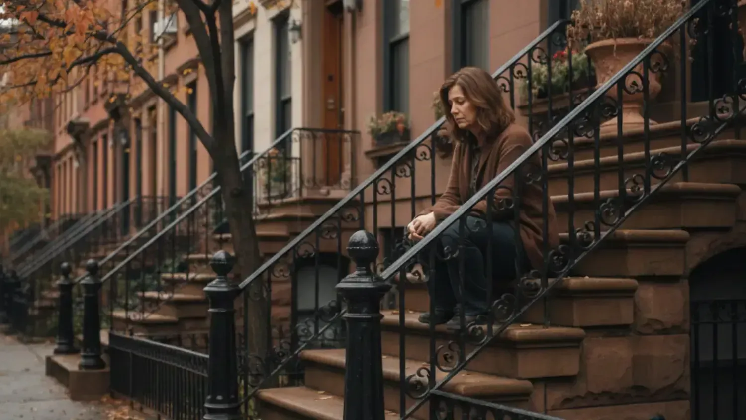 Woman sitting on steps of brownstone building looking discouraged, overcoming business excuses