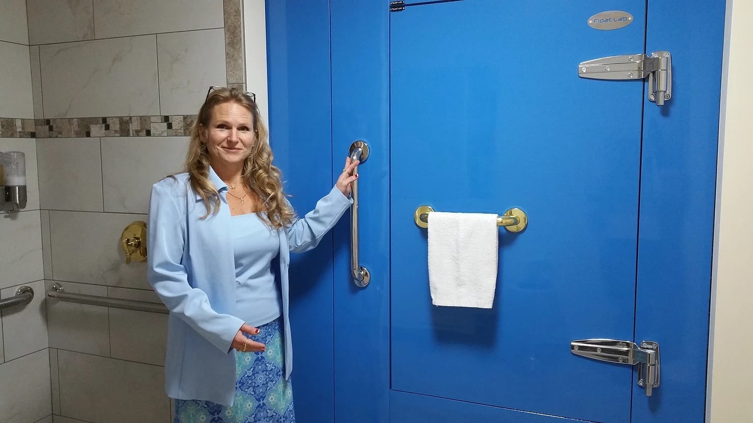 Elizabeth Heitzmann beside the Float Lab float tank at Float Doctor