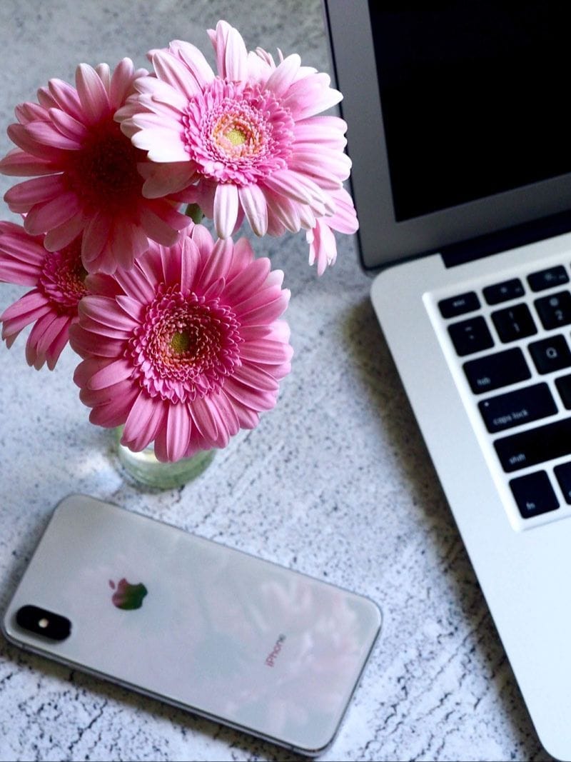 Small vase of pink flowers on a desk	