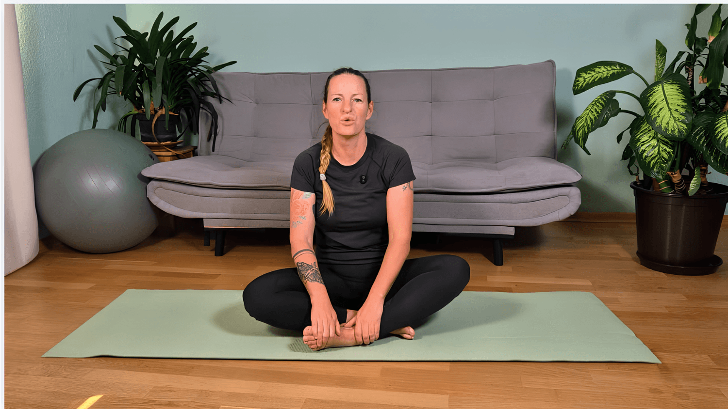 Alissa im Schneidersitz auf der Matte