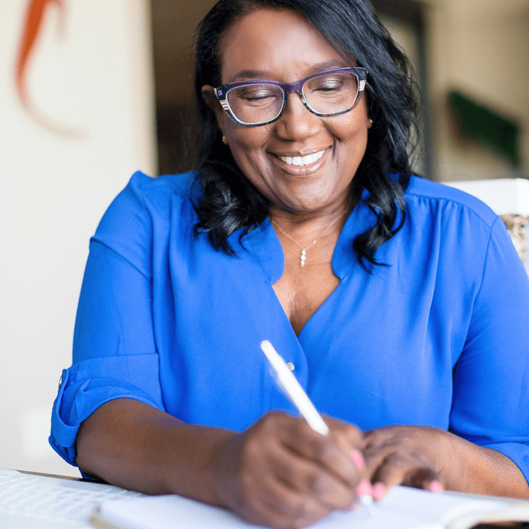Avril Fortuin writing in a notebook, planning a coaching session