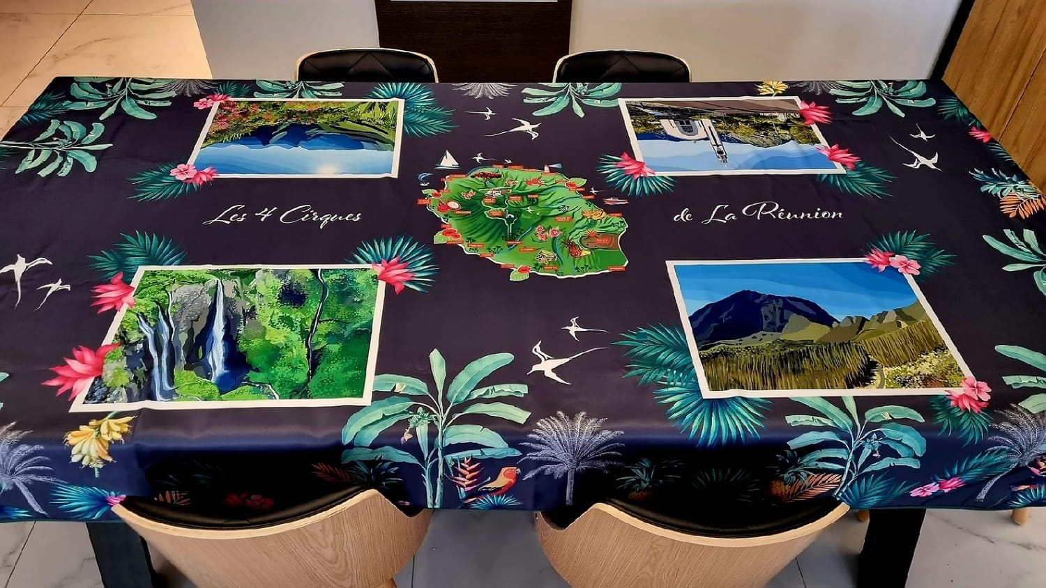 Visuel de nappe imprimée représentant les paysages emblématiques de La Réunion, décoration de table tropicale et colorée.