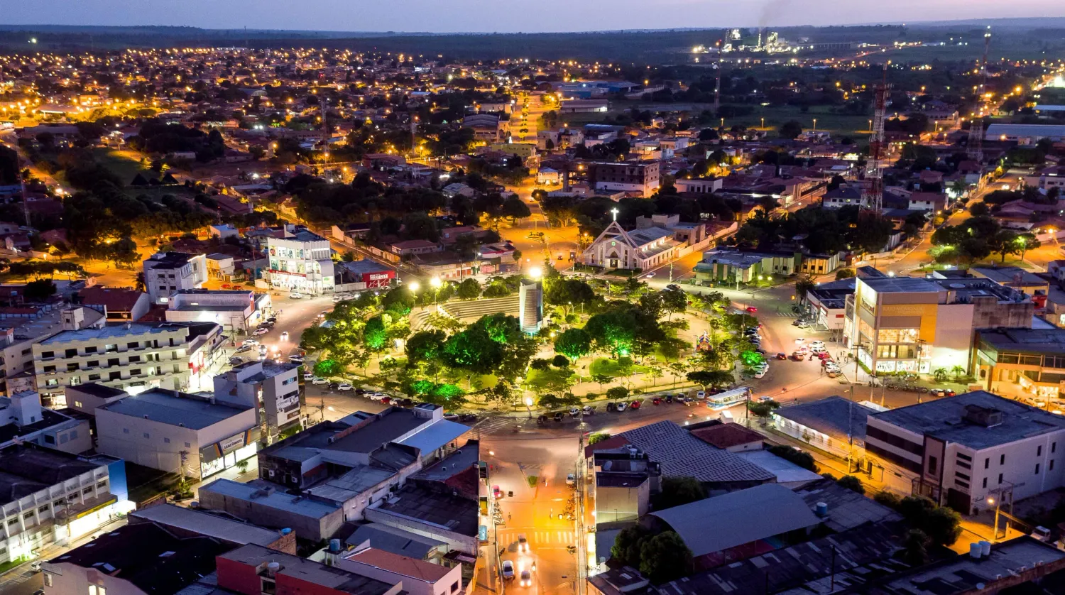 Vista aérea noturna da Praça Central de Paragominas — luzes da cidade iluminando ruas arborizadas