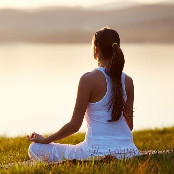 Mujer sentada en calma conectando con su cuerpo tras vivir en alerta constante