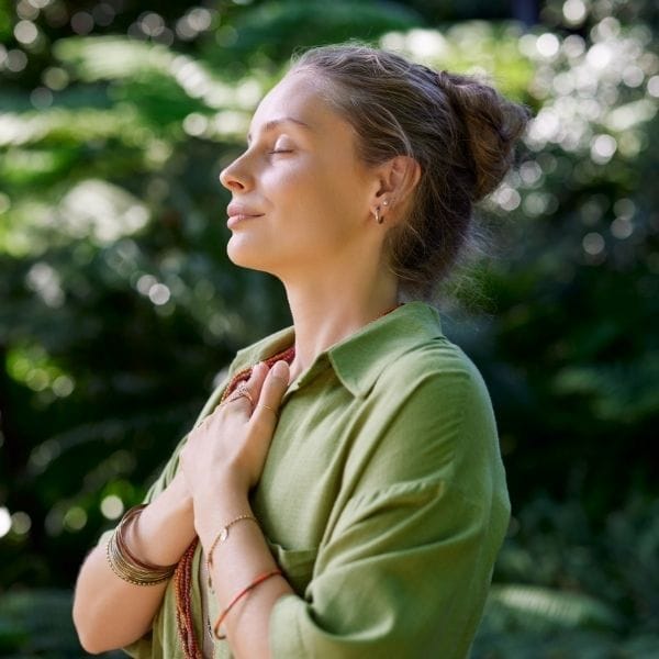 Mujer regulando su sistema nervioso y recuperando seguridad corporal en la naturaleza