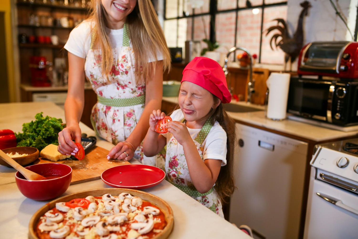 Mom and daughter cooking pizza together