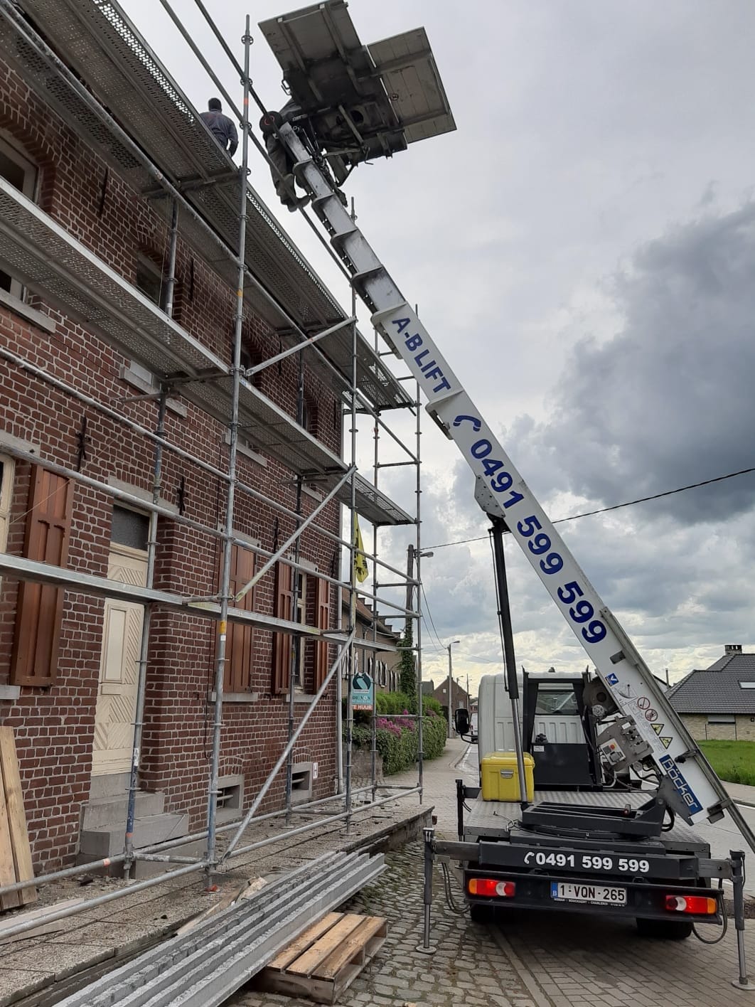 Lift AB Lift à côté d'un échafaudage sur un chantier de toiture