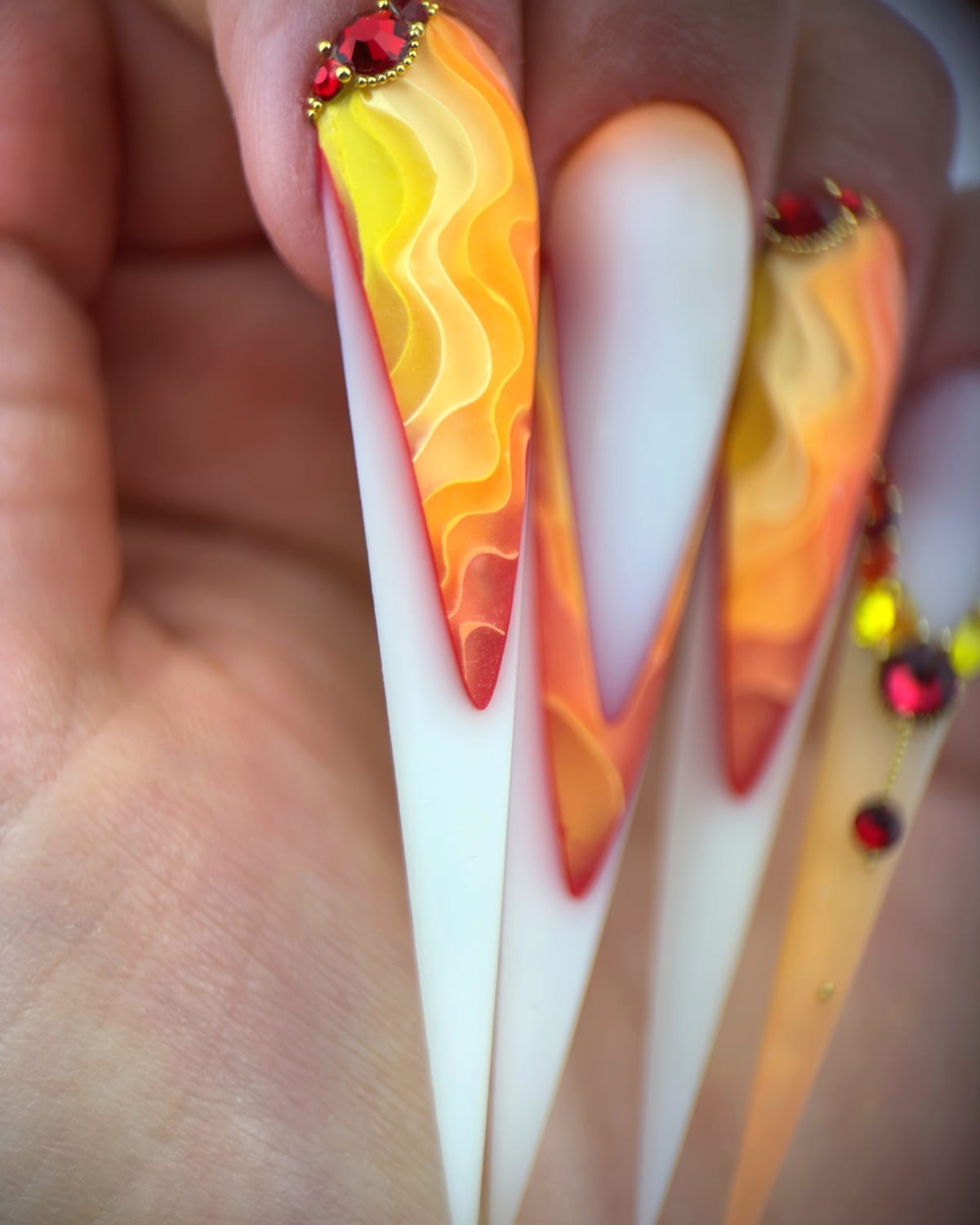 Pose d’ongles longs artistiques avec dégradés de couleur et travail en relief