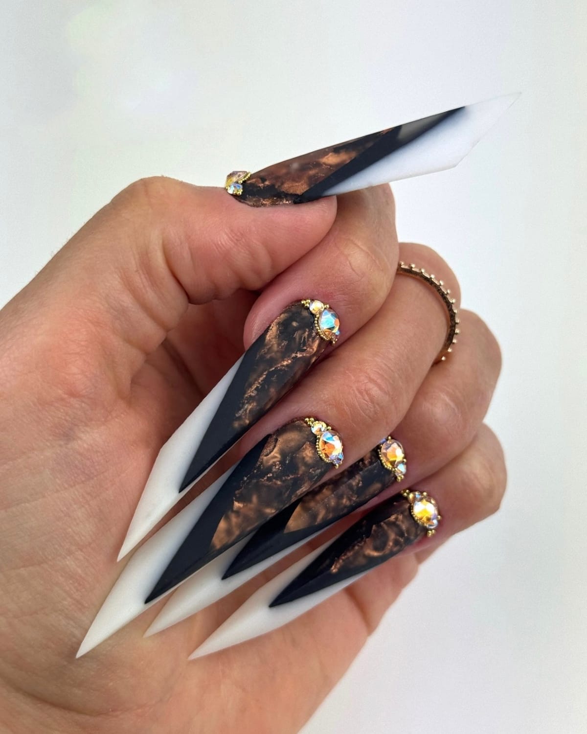 Pose d’ongles longs formes complexes avec contraste noir et blanc et incrustations