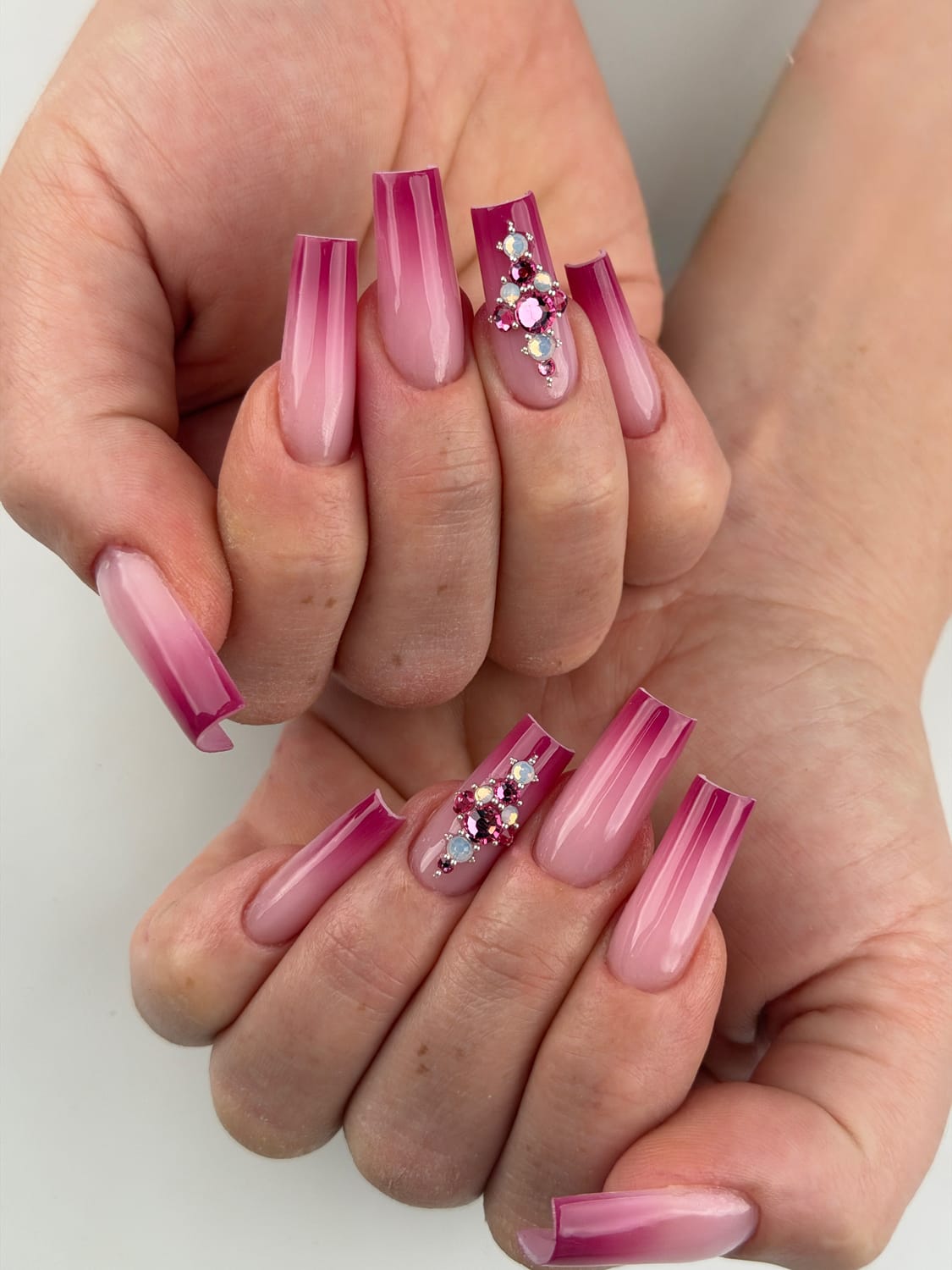 Pose d’ongles rose dégradée avec effet contour framboise et bijoux d’ongles réalisée par LENAILSBERTHOU