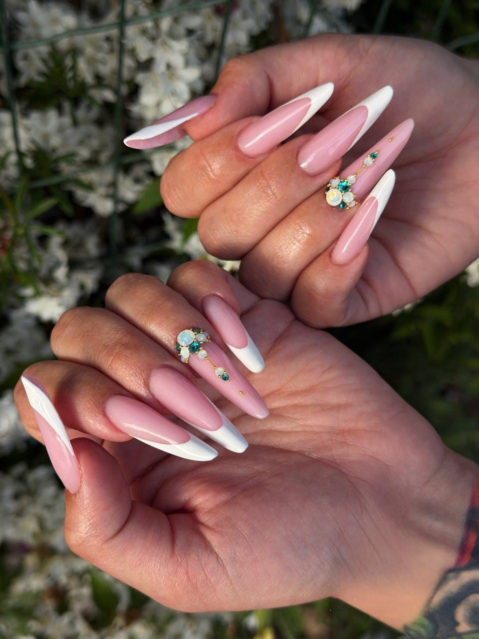 Pose d’ongles rose et blanche en forme amande avec French graphique et bijoux turquoise opalescents