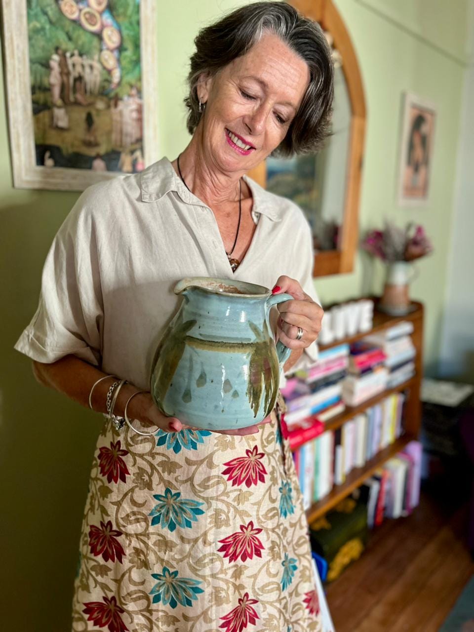 Smiling Milandre Vlok admiring a pottery pouring jug.