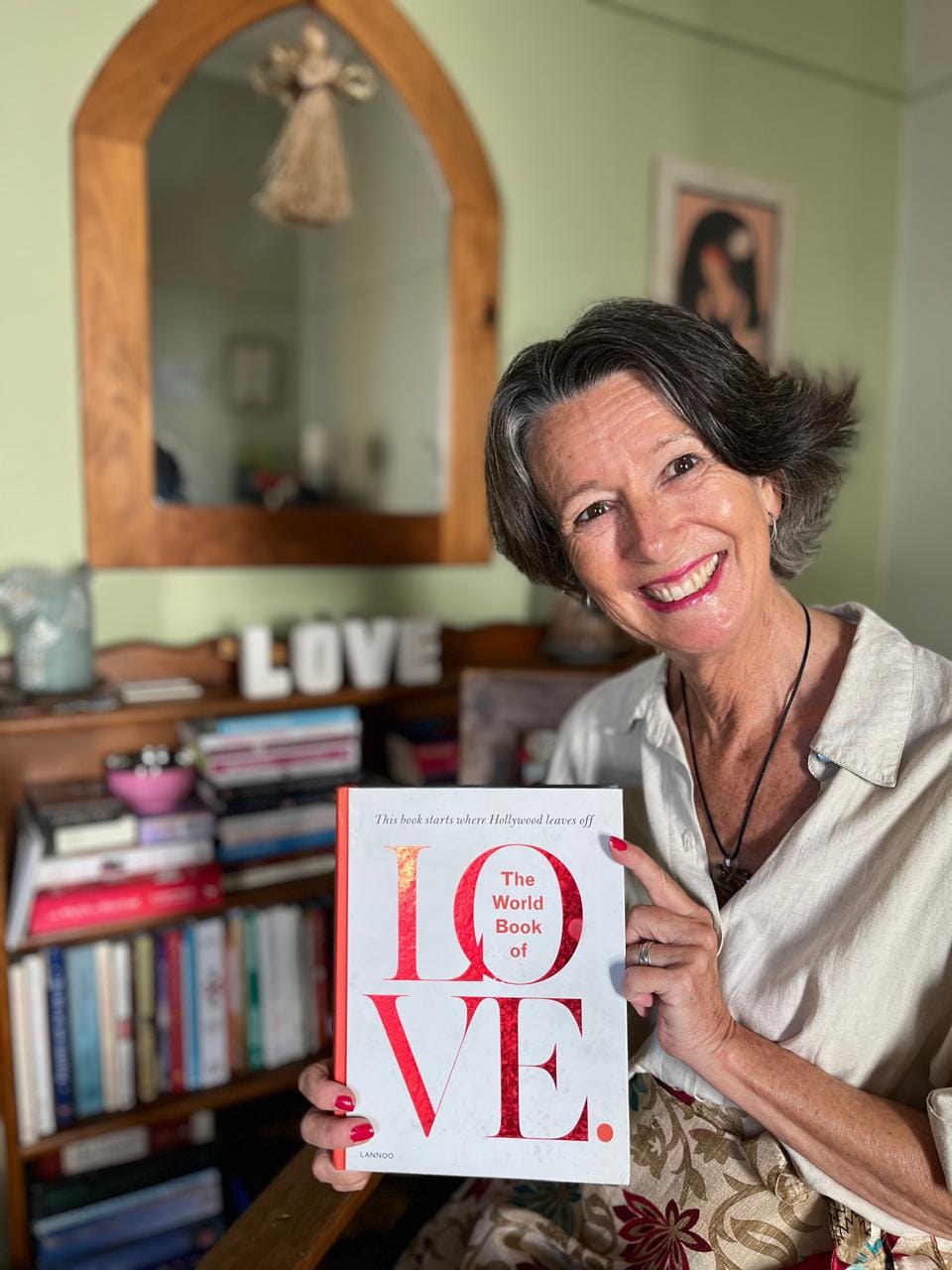 Smiling Milandre Vlok holding a copy of the book entitled The World Book of Love.