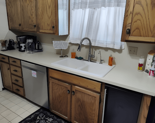 Black refrigerator and wine cooler beside stainless dishwasher