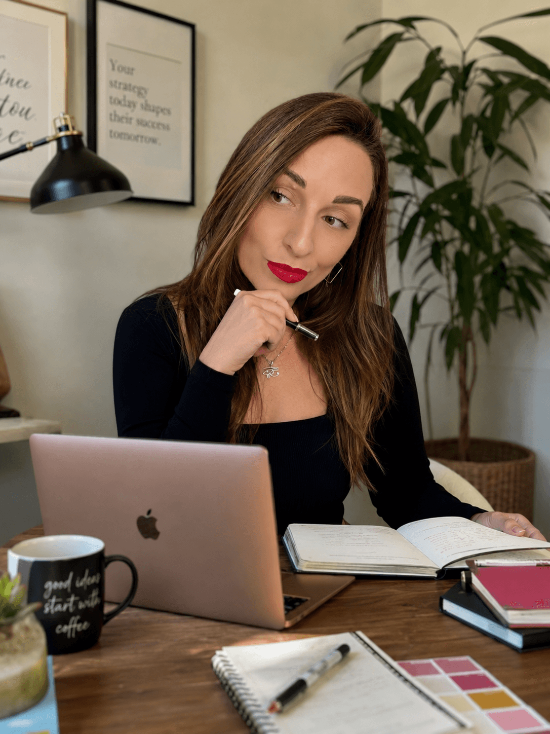 Aurélie, social media manager, elle a un air pensif. Elle est assise à son bureau, un agenda ouvert, un pc portable ouvert, une tasse de café. 