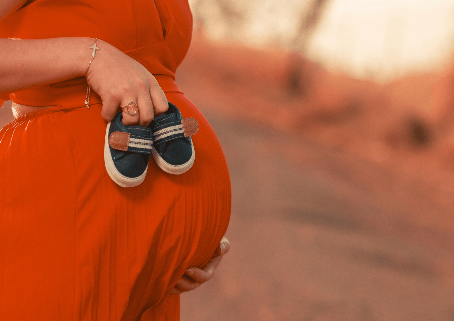 femme enceinte tenant chaussons de bébé
