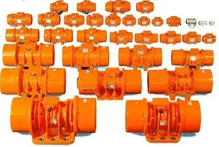 Vibrador eléctrico industrial montado en pared de tolva metálica descargando material a granel