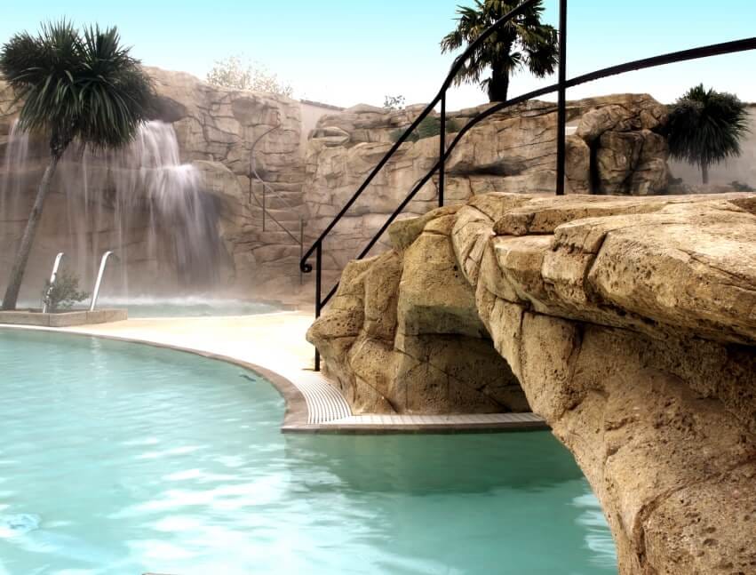 Cascade et plage de piscine en faux rocher réalisées en béton sculpté