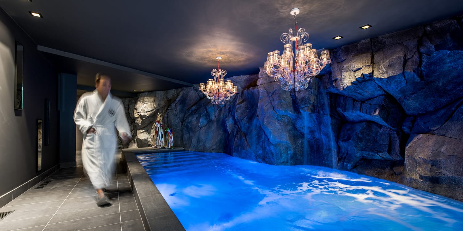 Piscine intérieure habillée d’un décor en faux rocher sculpté à la main