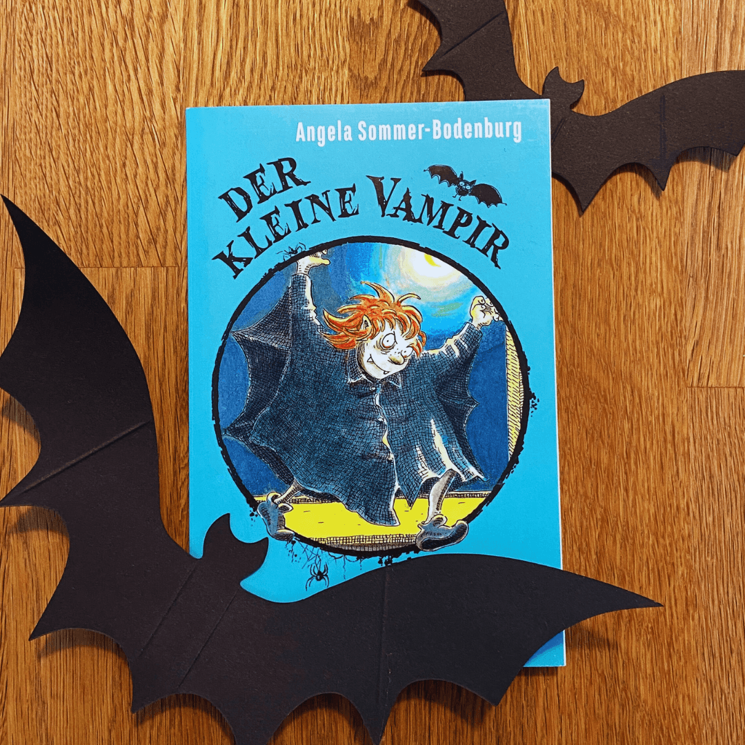 Buchcover von „Der kleine Vampir“ von Angela Sommer-Bodenburg auf einem Holztisch mit Herbstlicht. Ein Klassiker unter den Kinderbüchern – ideal für kleine Gruselfans zu Halloween.