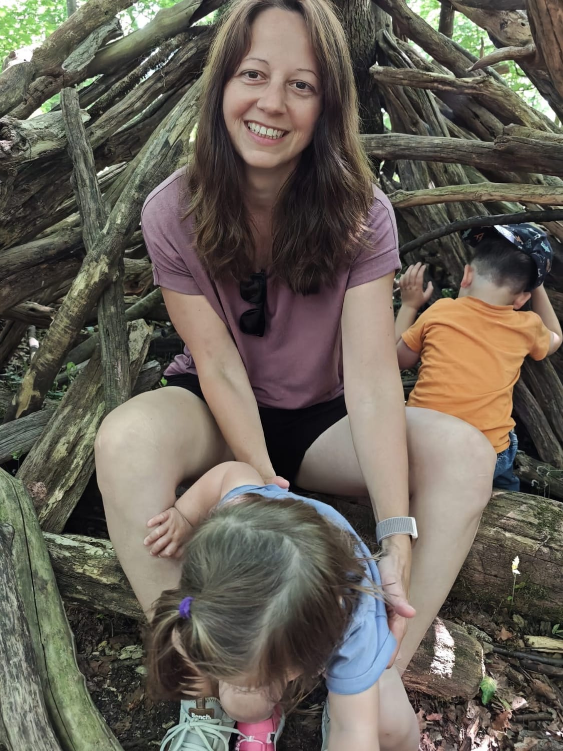 Jenny mit ihren beiden Kindern beim Spielen im Wald